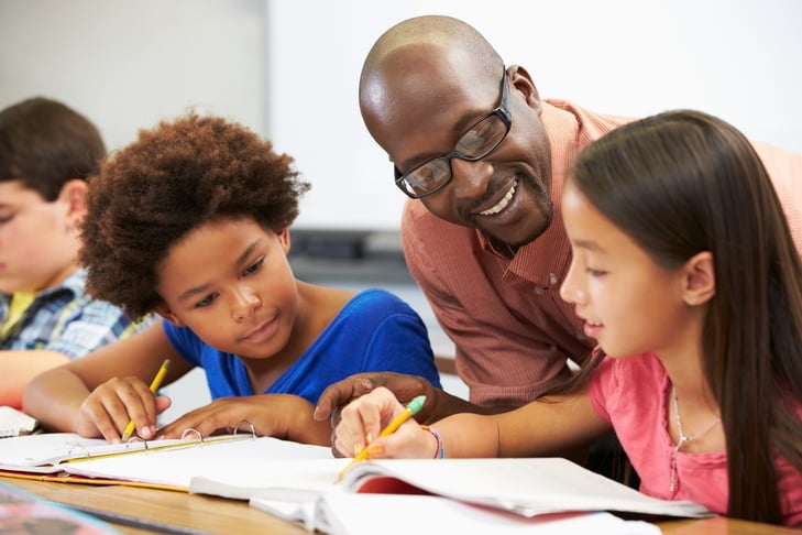 school teacher helping young students school teacher helping young students